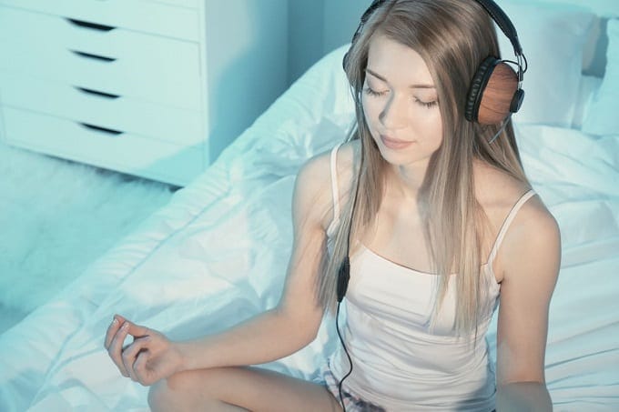 Young Woman Listening To Music While Meditating