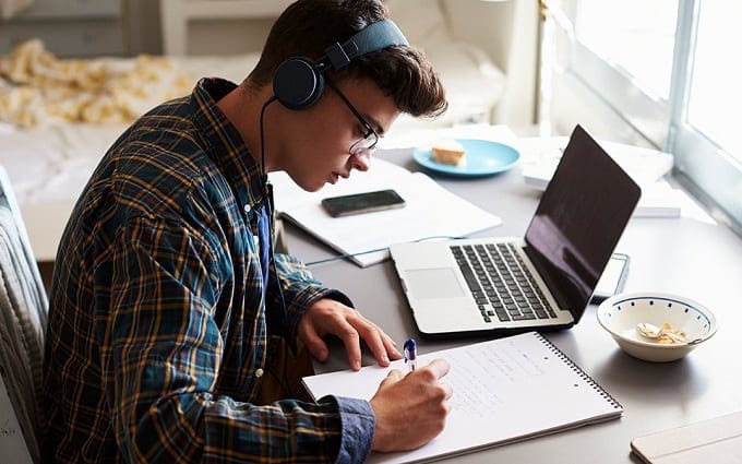 Young Man Listening To White Noise While Studying
