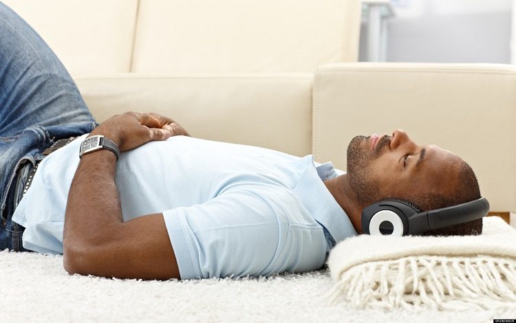 man lying on couch with headphones