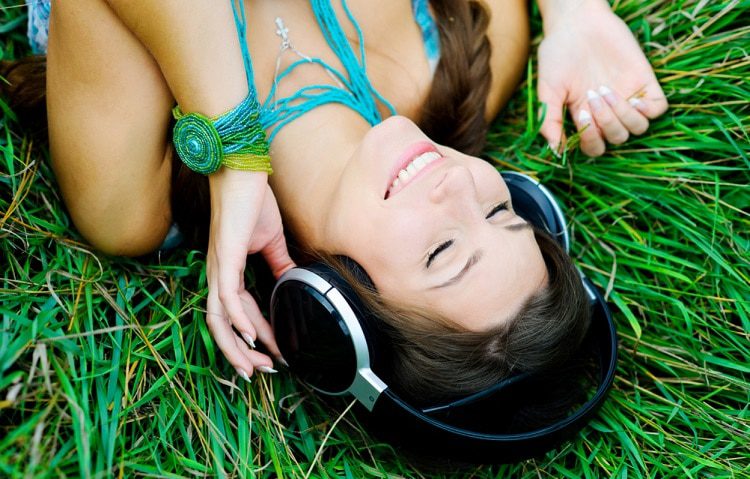 girl lying in grass and listen music