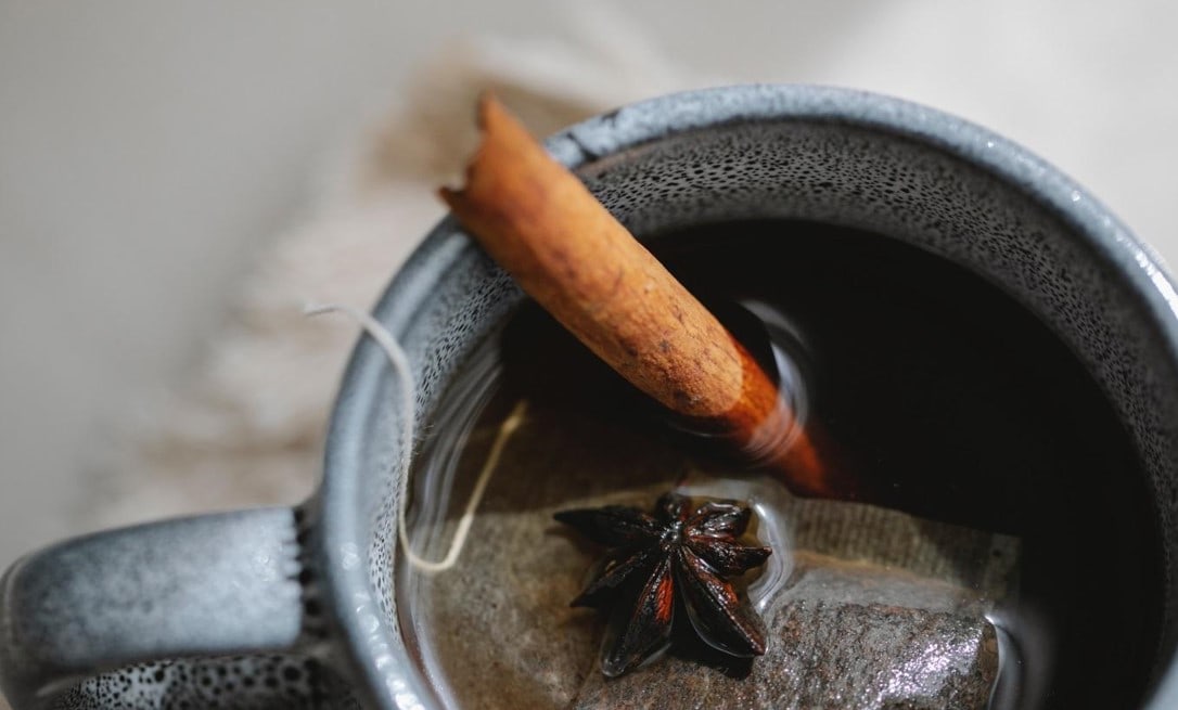 cup of tea with a teabag and cinnamon stick