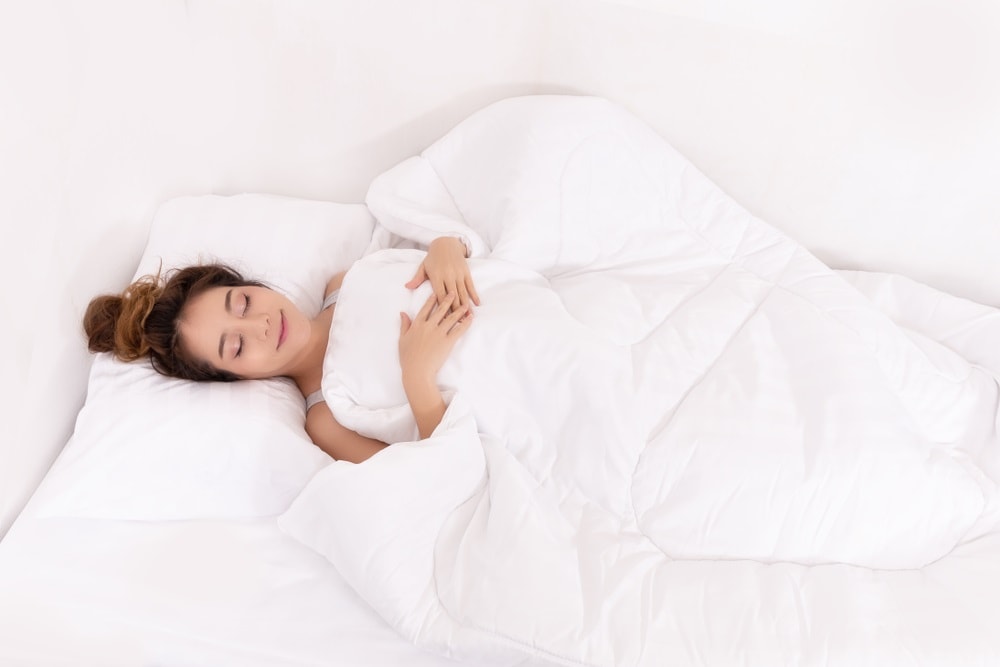 How to get more REM Sleep. women in sports pajamas sleep happily on bed