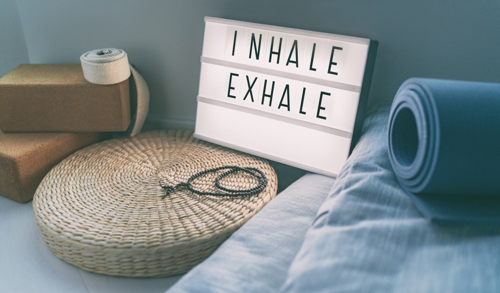 yoga breathing inhale exhale sign at fitness class on lightbox inspirational message with exercise mat