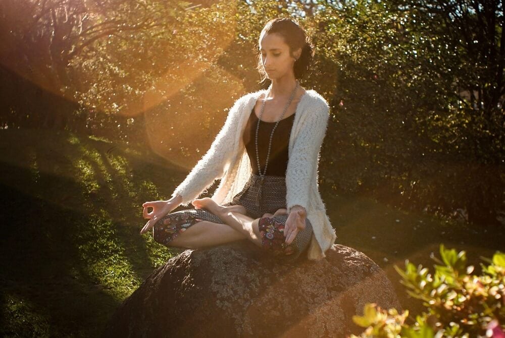 woman practicing meditation outdoors