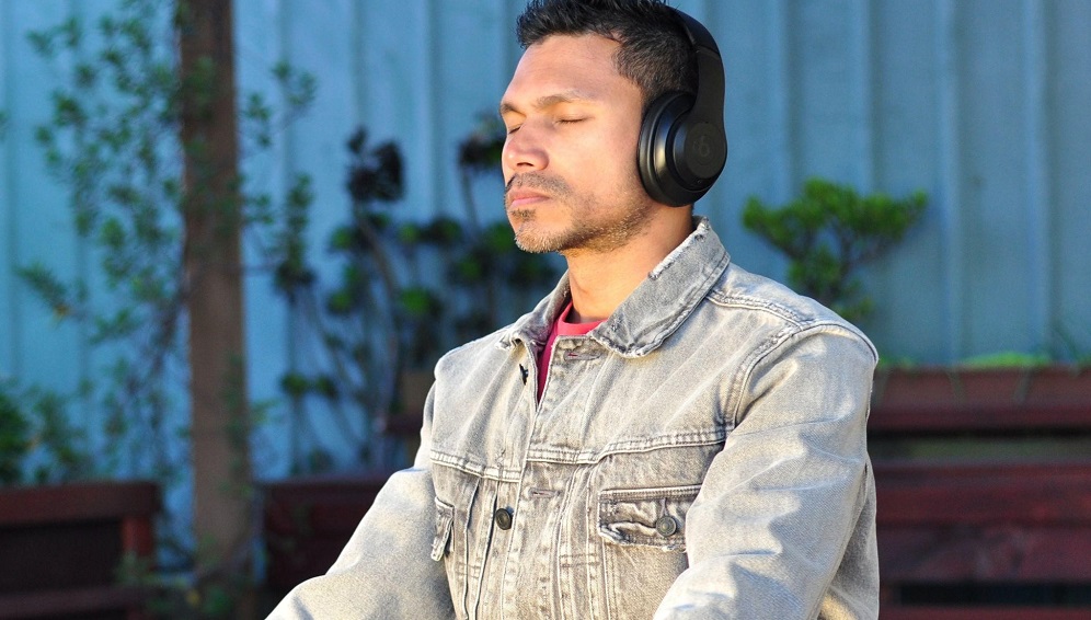 A man meditating and listening to music