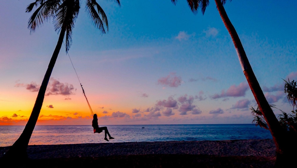 A silhouette of a person on a swing