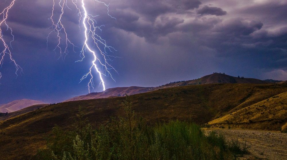 Lightning strikes over hills