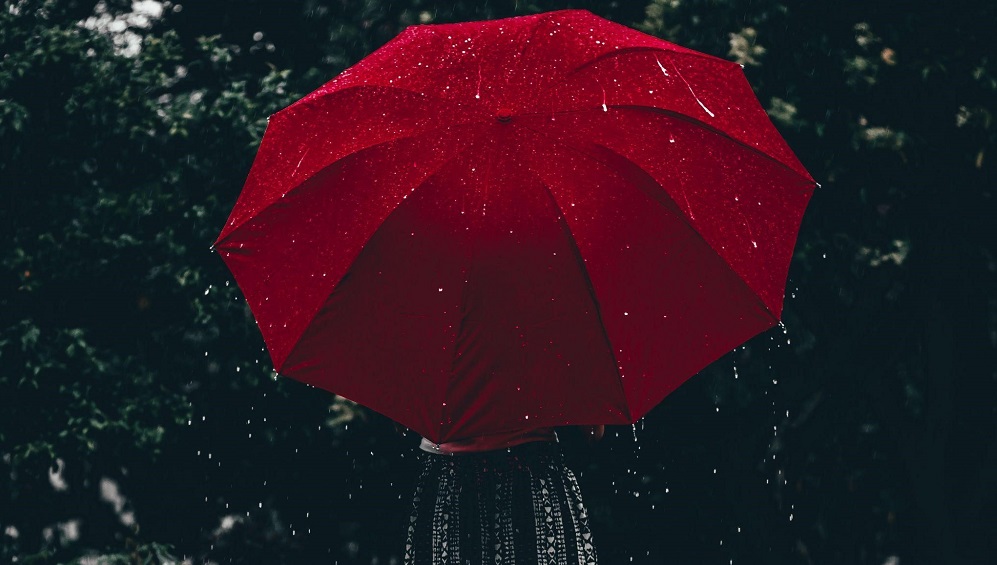 Rain falling on a red umbrella
