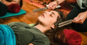 Woman in a sound therapy session involving tuning forks