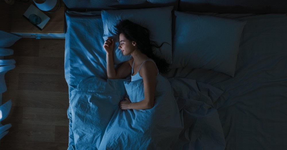 Woman lying on her side in bed at night