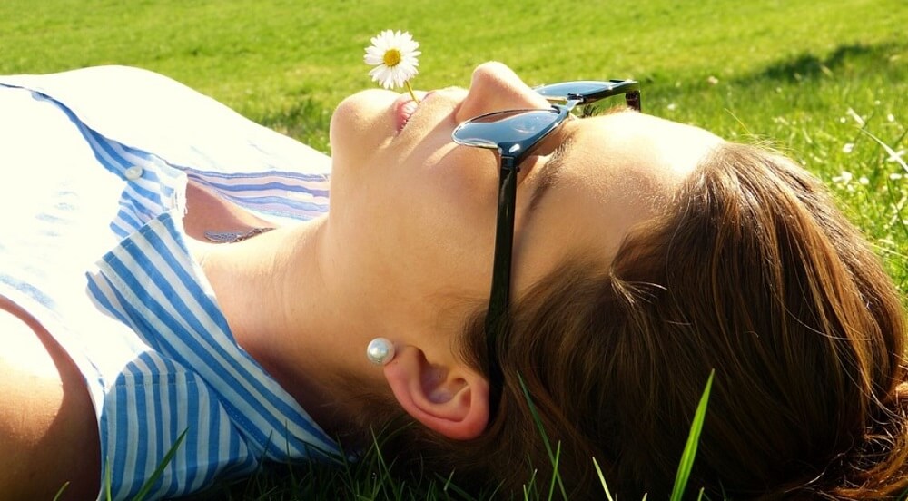 Woman wearing sunglasses relaxing in the meadow