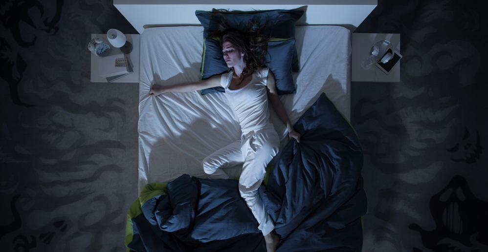 Nervous woman in bed have a nightmare at midnight