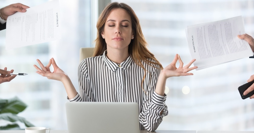 female executive meditating taking break at work for mental balance