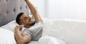 man stretching in bed after nice sleep