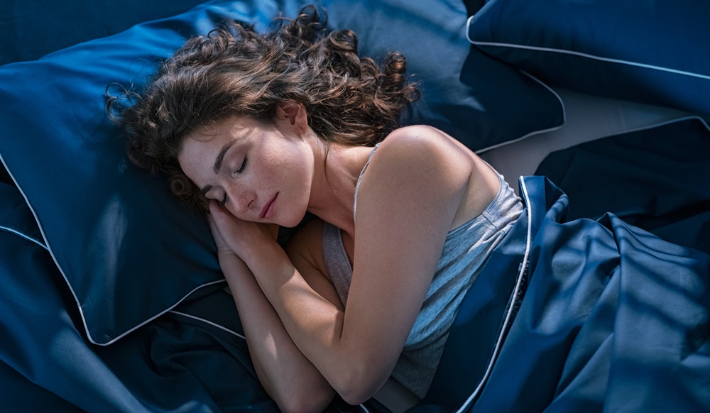 view of young beautiful woman dreaming in bed and relaxing at night