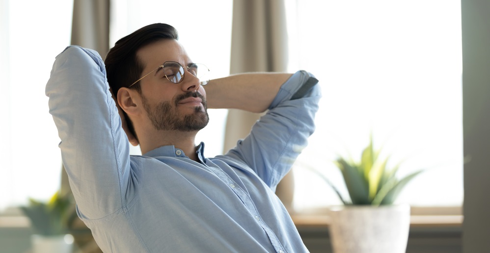 young man wearing glasses daydreaming with closed eyes